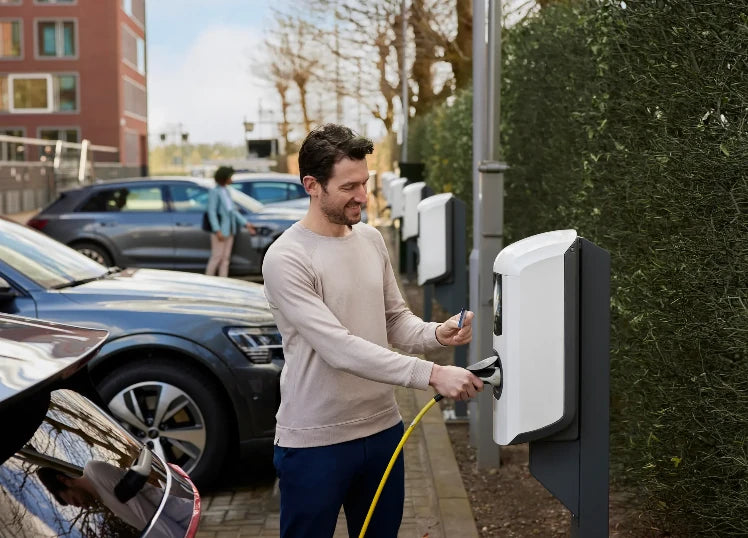 Man laadt zijn auto bij een Alfen Eve Double op een laadpaal