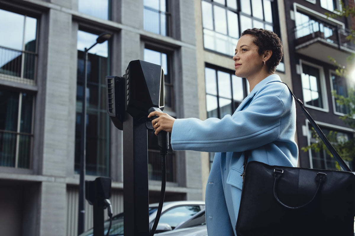 Vrouw laadt haar auto bij een Easee Charge Pro op een laadpaal
