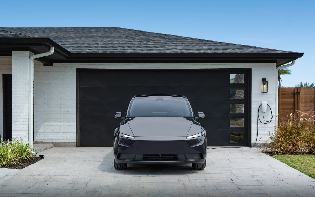 Tesla Wall Connector aan de garagemuur bij een oprit