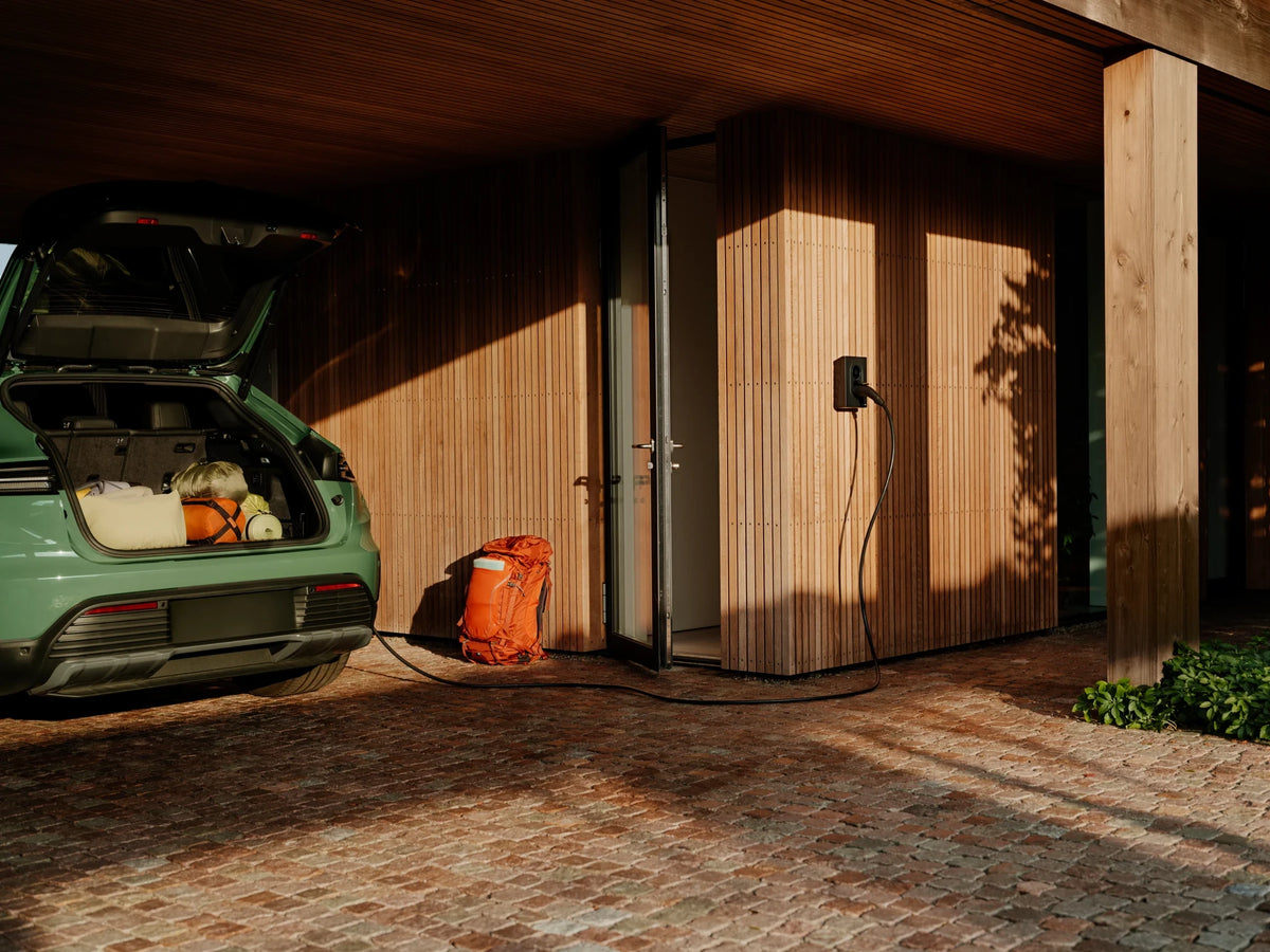 Groene auto laadt onder een carport aan een Zaptec Go 2
