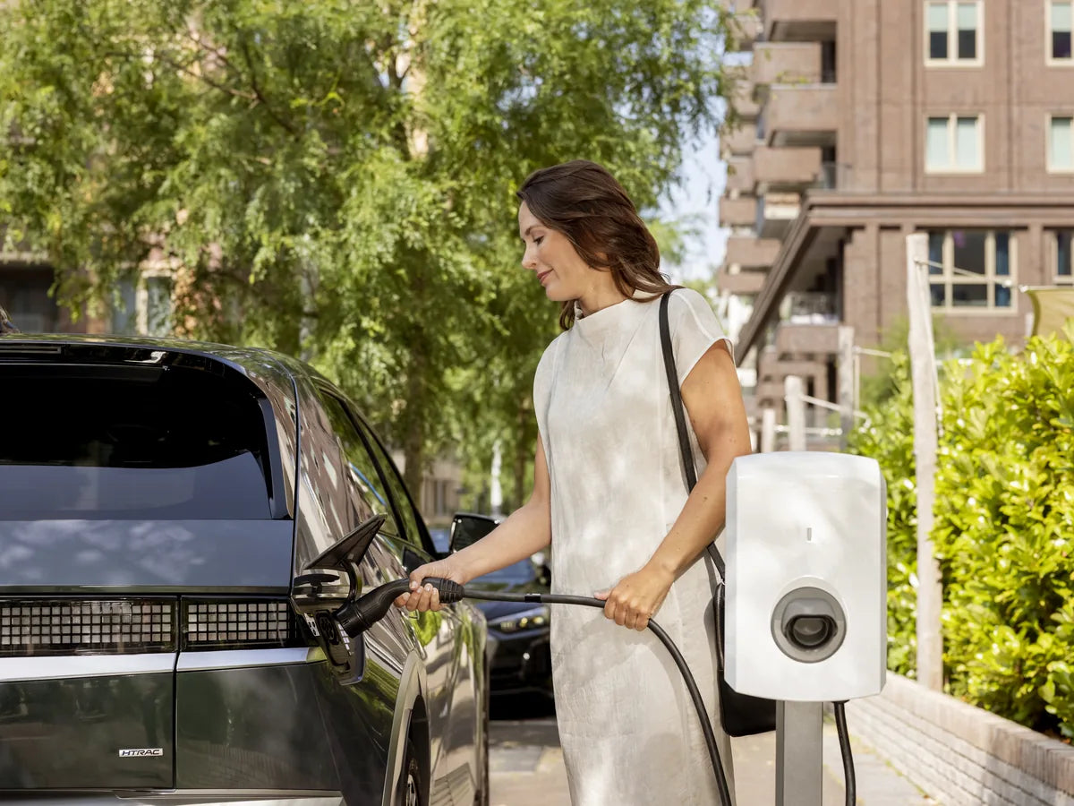 Vrouw laadt haar auto aan een witte Alfen Eve Single S-line