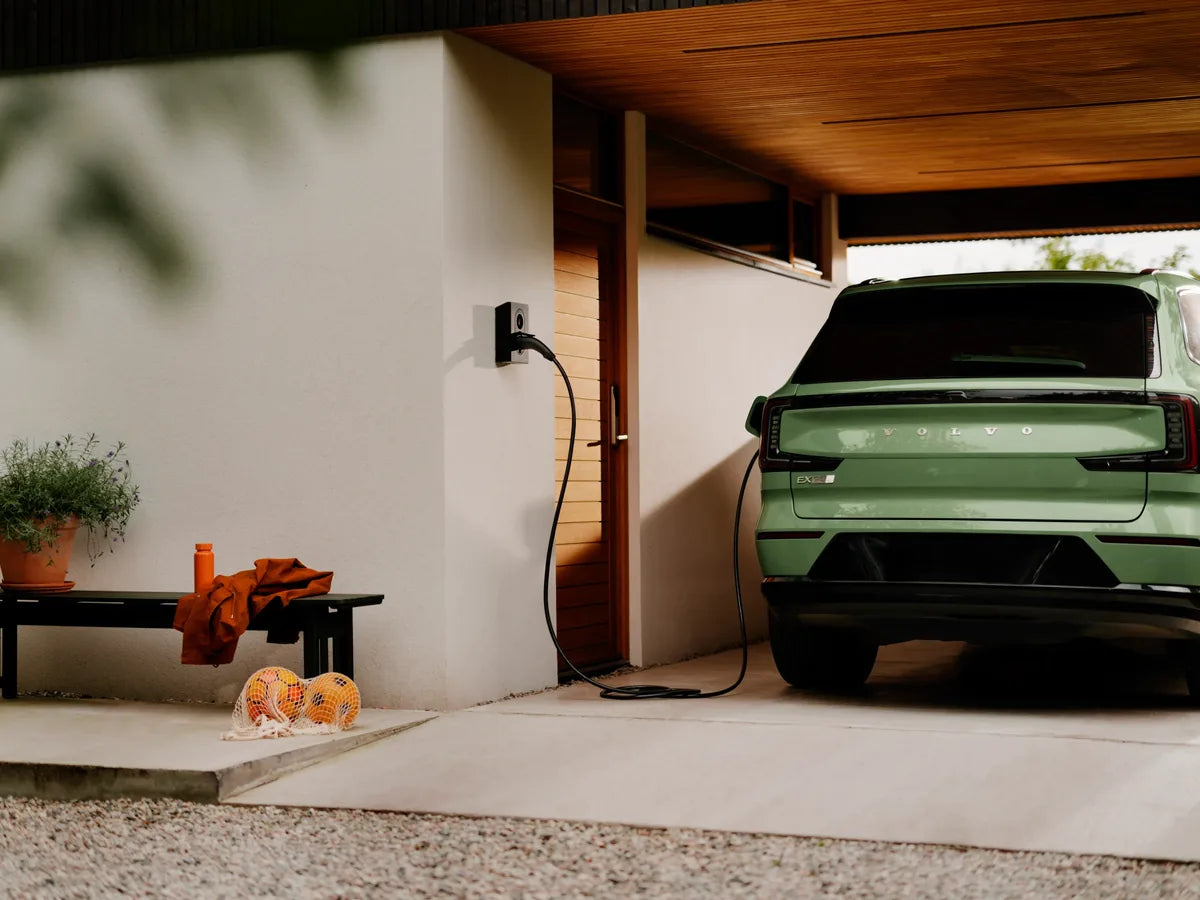 Groene elektrische auto laadt onder een carport aan een Zaptec Go 2